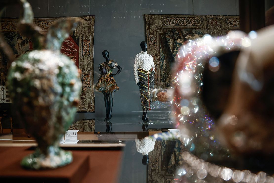 Fashion designs including a dress from Alexander McQueen's Spring-Summer 2010 collection (left) at the show at the Louvre Museum.